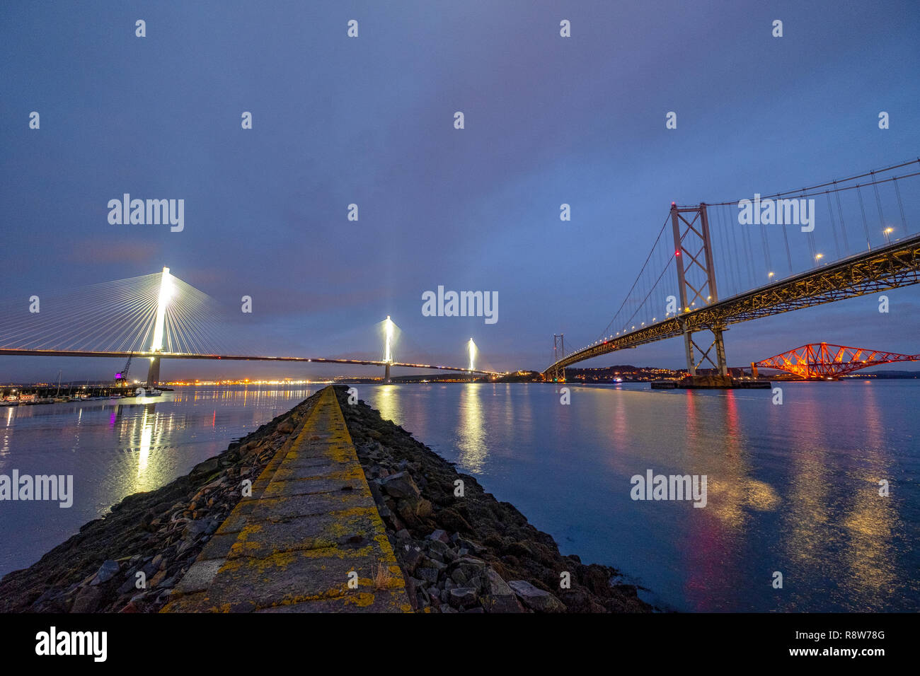 View at dusk of the new Queensferry Crossing bridge, Forth Road bridge and Forth Rail bridge from Port Edgar South Queensferry. Stock Photo