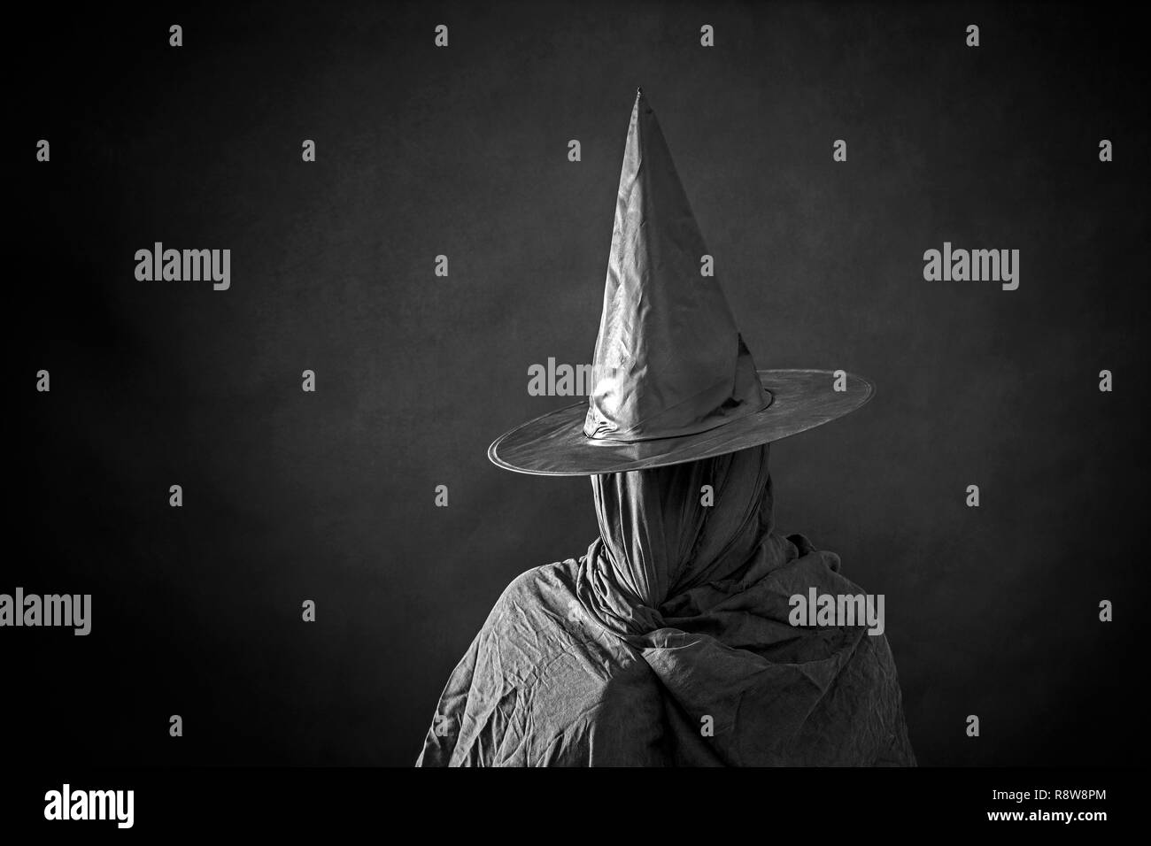 Ghostly figure with long hat in the dark Stock Photo