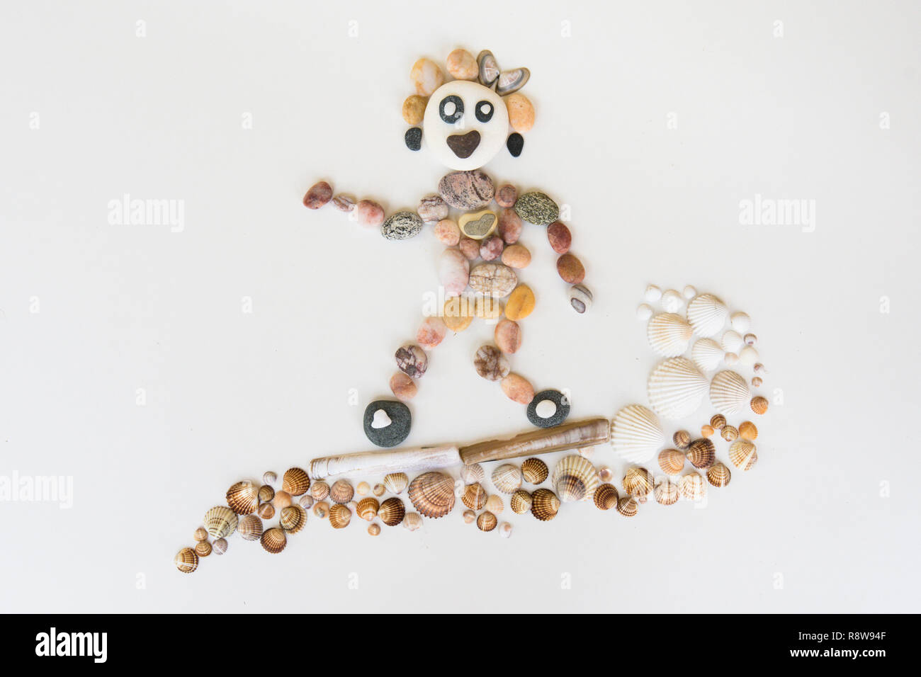 natural art, craft, picture of person surfing, made from pebbles, shells, Stock Photo