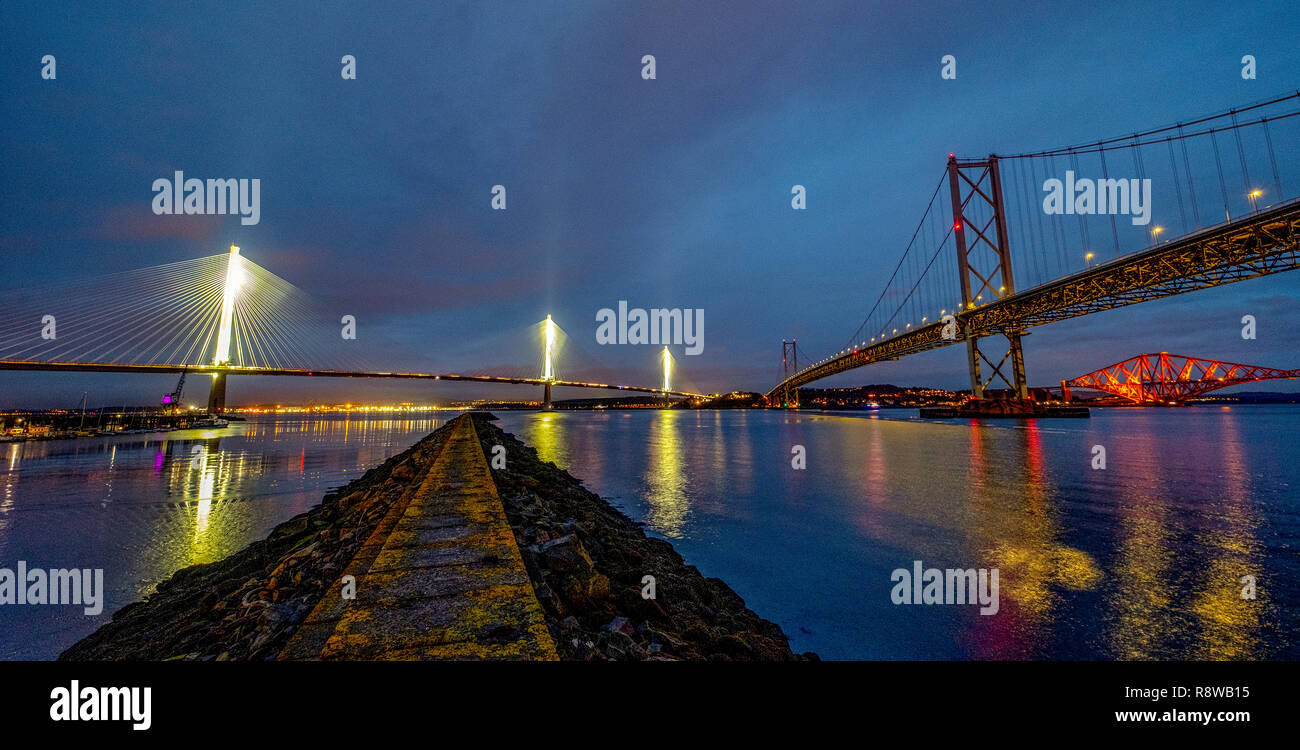 View at dusk of the new Queensferry Crossing bridge, Forth Road bridge and Forth Rail bridge from Port Edgar South Queensferry. Stock Photo