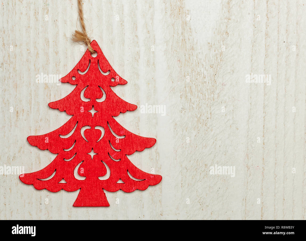 Red wooden Christmas sapling on white wood background. Decentralized object with space for text. Stock Photo