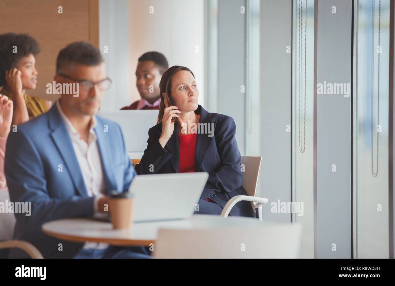 Thoughtful businesswoman looking out window in cafeteria Stock Photo