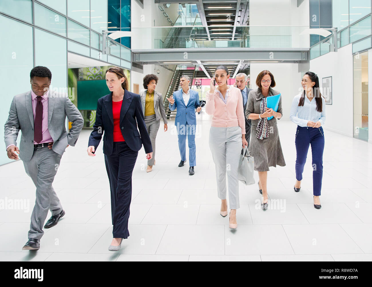 Business people walking in modern office atrium lobby Stock Photo
