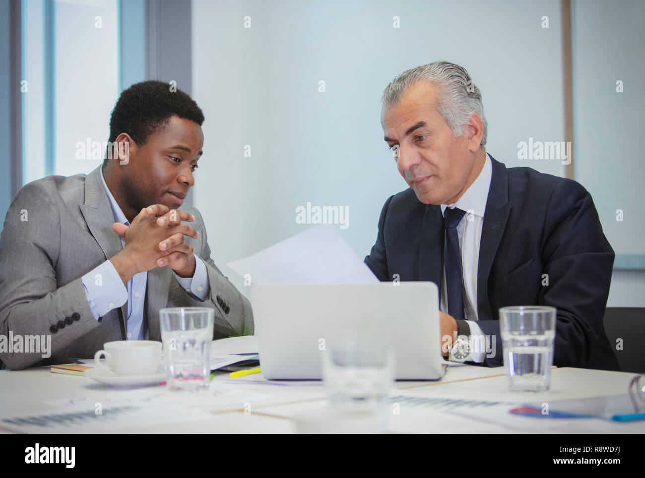 Businessmen discussing paperwork in meeting Stock Photo
