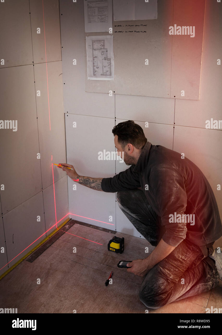 Construction worker using laser measuring tool Stock Photo
