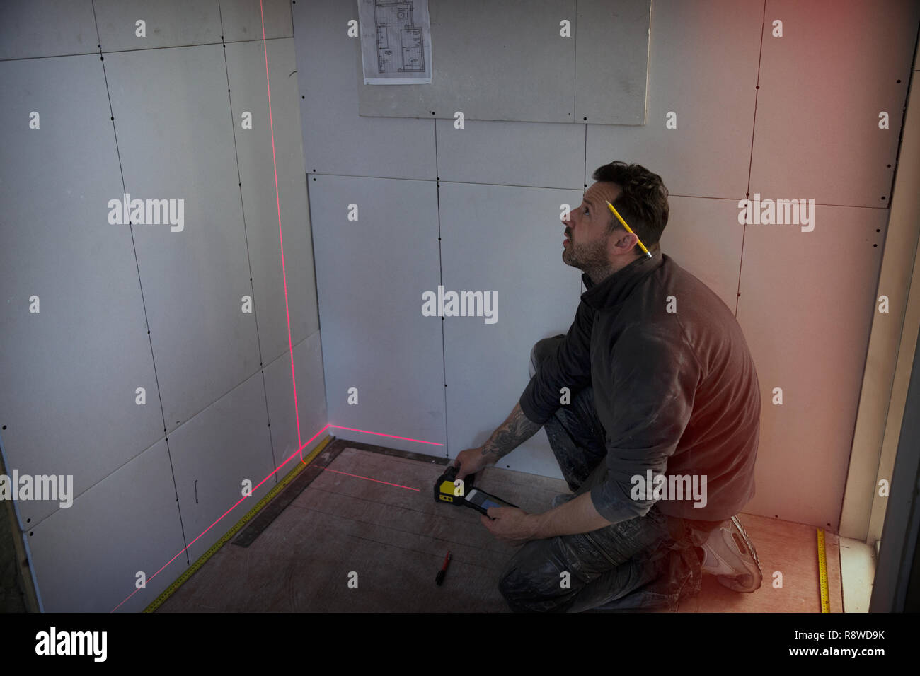 Construction worker using laser measuring tool Stock Photo