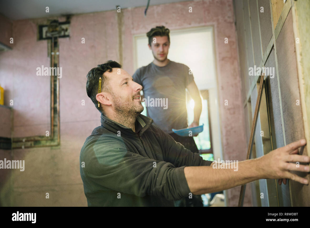 Construction workers framing inside of house Stock Photo