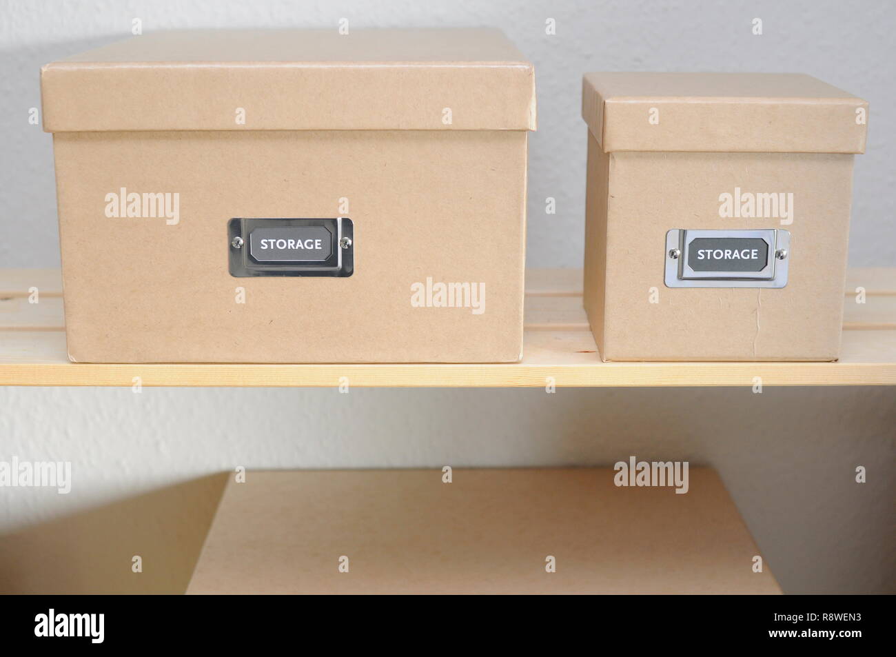 Plain cardboard storage boxes on a shelf. Stock Photo