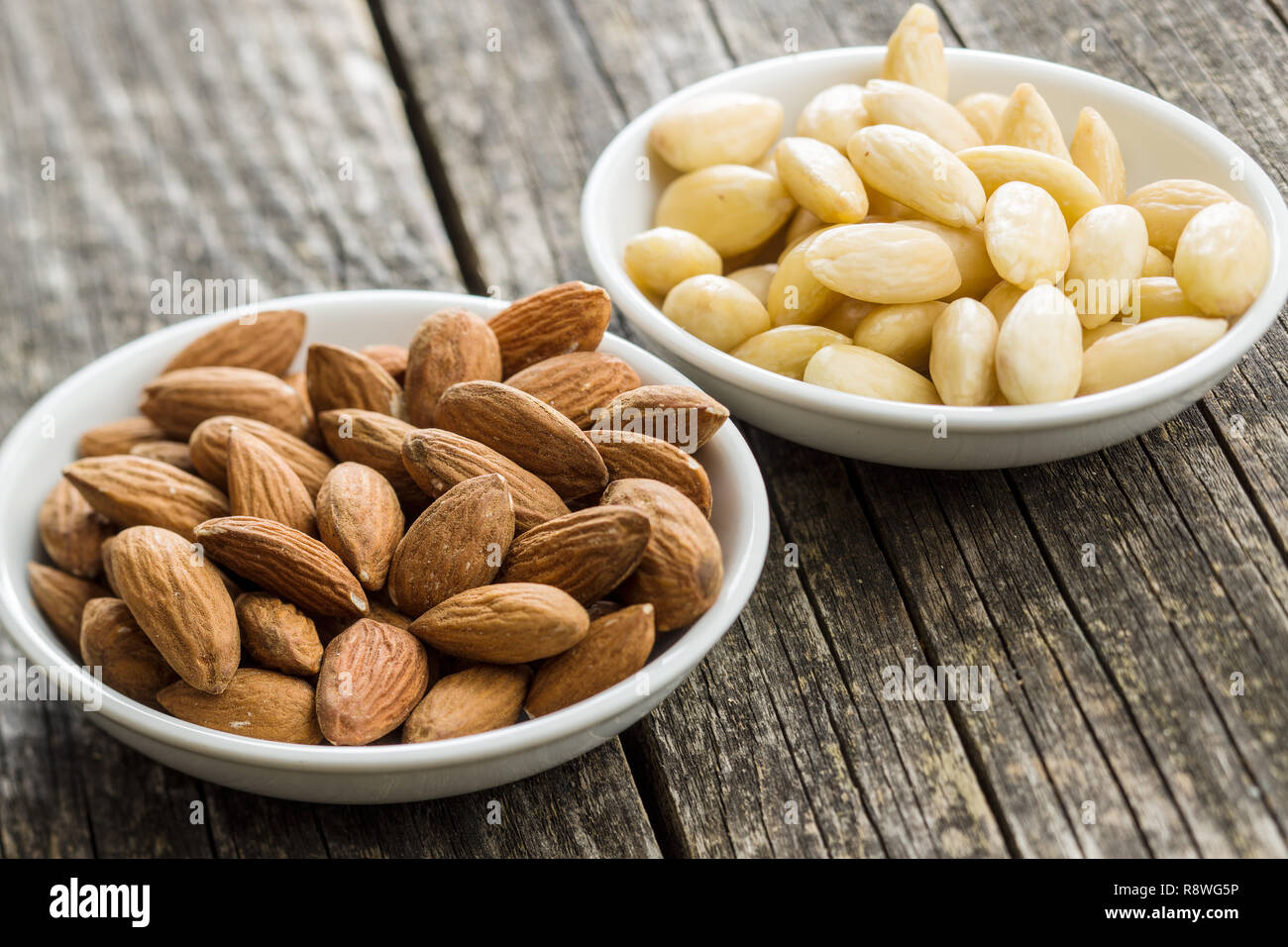 Peeled and unpeeled almonds in bowl Stock Photo Alamy