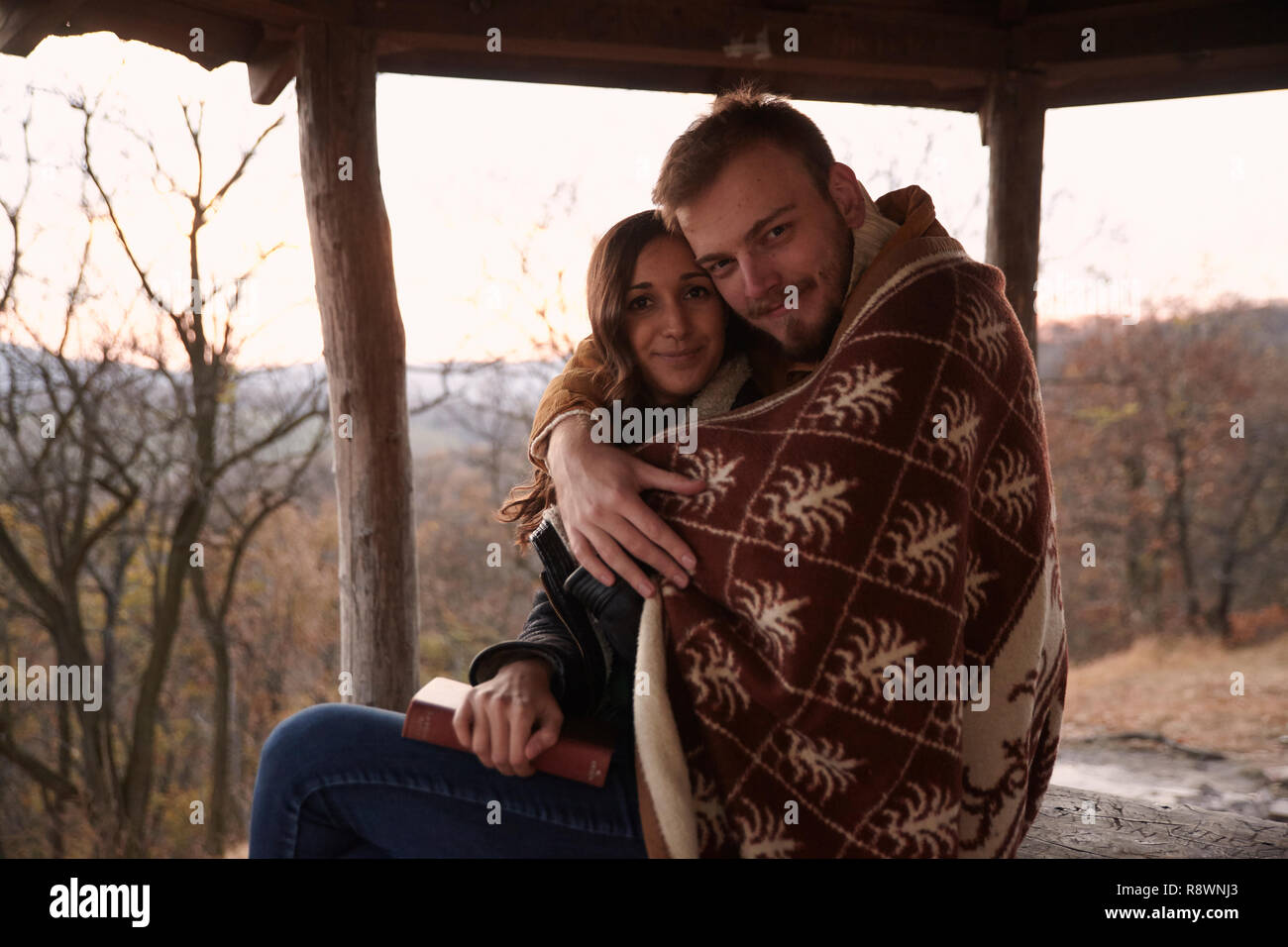 two people, young couple, hugging under a blanket, in rural area. In