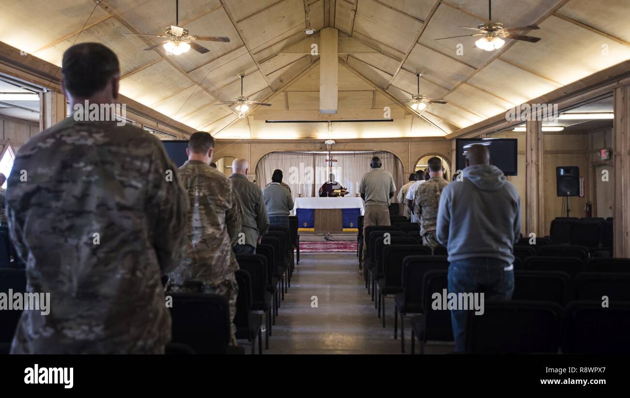 Service members, Defense Department civilian employees and contractors sing during Sunday Mass March 12, 2017 at the Fraise Chapel, Kandahar Airfield, Afghanistan. Chaplain (Capt.) Robbie Deka, 455th Air Expeditionary Wing, serves as the only Air Force chaplain at Kandahar. He and the sister service chaplains assigned there offer a variety of religious services for all faiths throughout the week at Fraise Chapel. Stock Photo