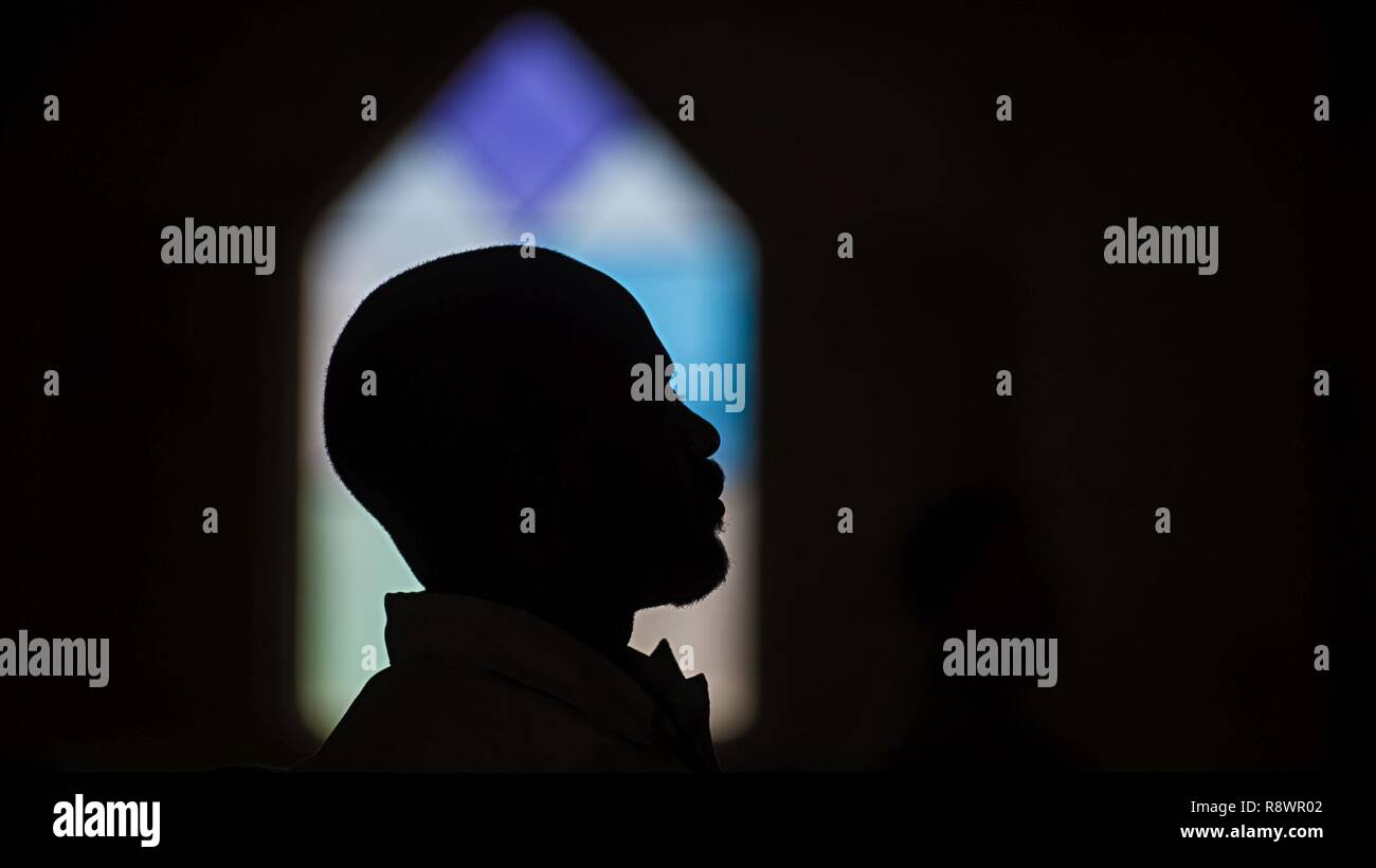 A churchgoer prays during Sunday Mass March 12, 2017 at the Fraise Chapel, Kandahar Airfield, Afghanistan. Chaplain (Capt.) Robbie Deka, 455th Air Expeditionary Wing, serves as the only Air Force chaplain at Kandahar. He and the sister service chaplains assigned there offer a variety of religious services for all faiths throughout the week at Fraise Chapel. Stock Photo