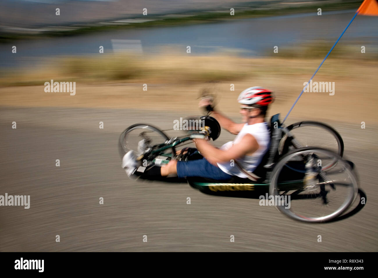 WA02962-00...WASHINGTON - Ed Farrar paralyzed from the chest down rides his hand crank tricycle on the Wenatchees Loop Trail. Stock Photo