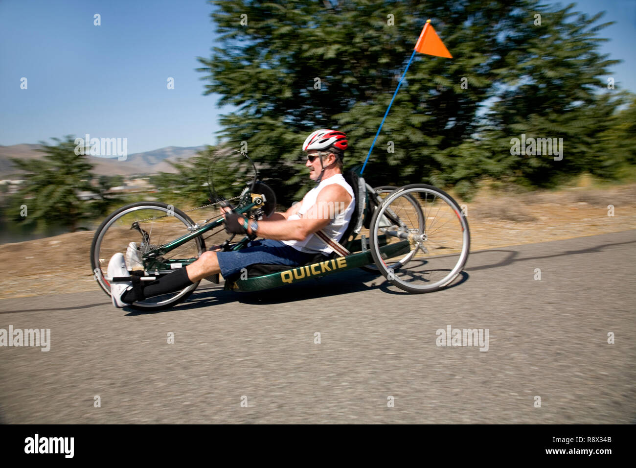 WA02964-00...WASHINGTON - Ed Farrar paralyzed from the chest down rides his hand crank tricycle on the Wenatchees Loop Trail. Stock Photo