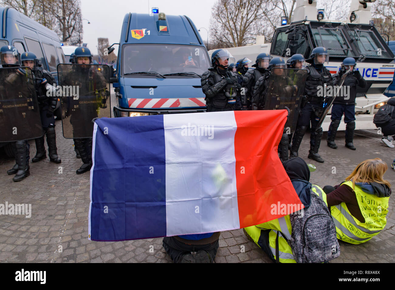 Yellow Vests demonstration (Gilets Jaunes) protesters against fuel tax, government, and President Macron with flag at Champs-Élysées, Paris, France Stock Photo