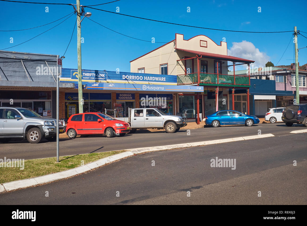 Shops along the side of the street including a hardware store with vehicles parked outside in Dorrigo New South Wales, Australia Stock Photo