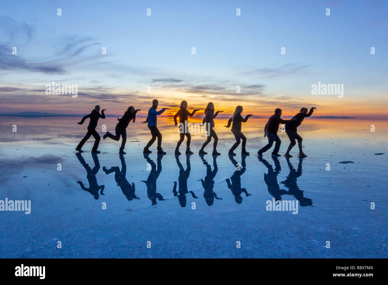 People reflections at Uyuni saltflats. One of the most amazing things that a photographer can see. The sunrise over an infinite horizon at Uyuni Stock Photo