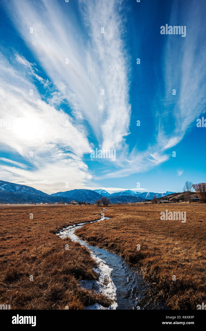 Ranch irrigation ditch & pasture; dramatic sky; Rocky Mountains; outside small town of Salida; Colorado; USA Stock Photo