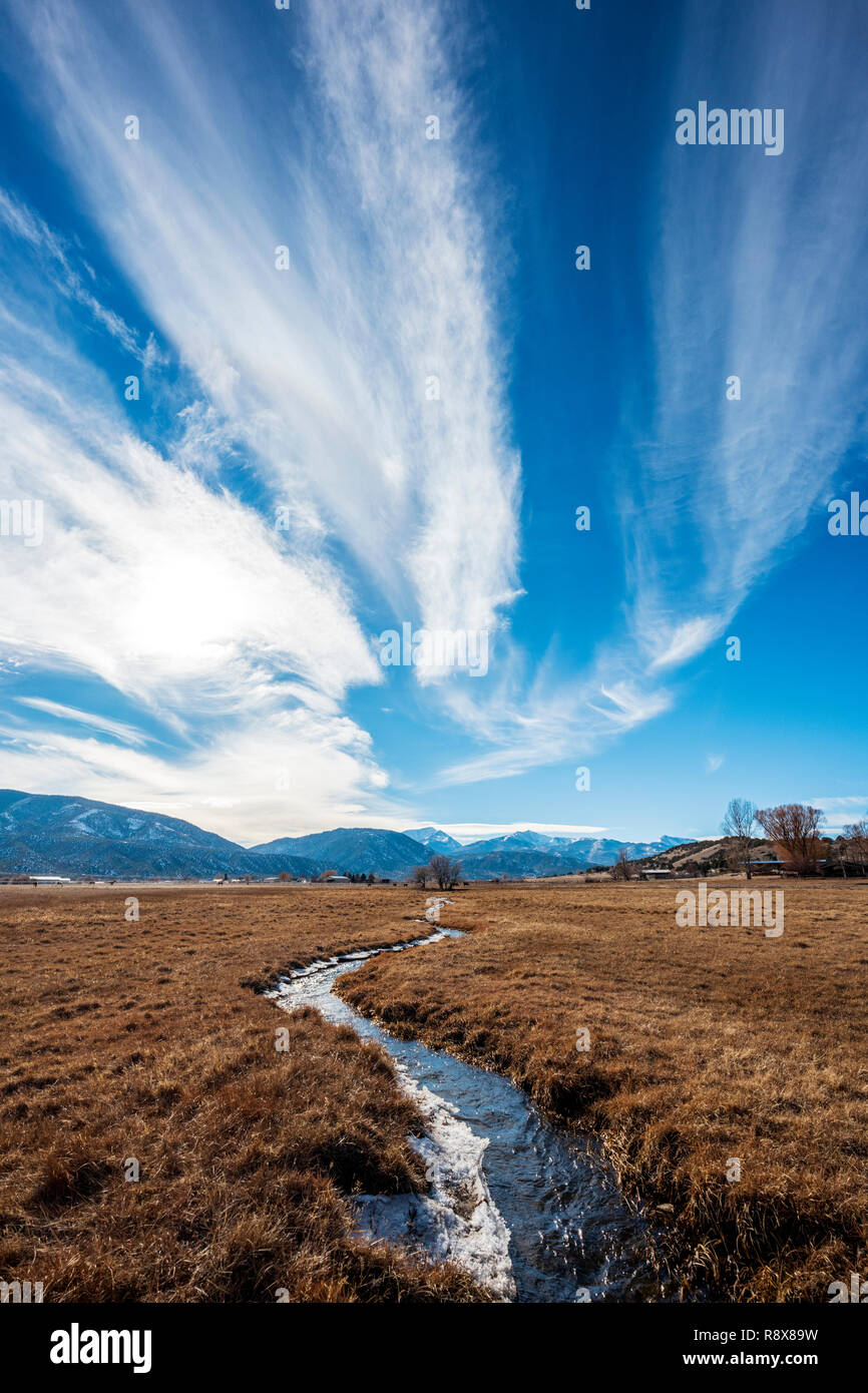 Ranch irrigation ditch & pasture; dramatic sky; Rocky Mountains; outside small town of Salida; Colorado; USA Stock Photo