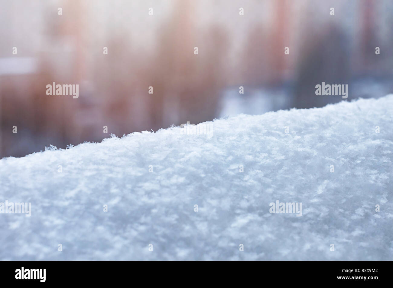A Snowdrift with Snowflakes on a Blurred Apartment Building Background. Winter Season, Weather Forecast, Climate Change Image. Stock Photo