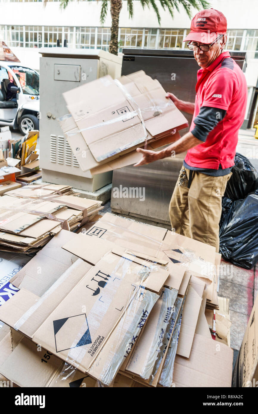 Miami Florida,downtown,Hispanic man men male,breaking down cardboard boxes taking apart,recycling,FL181205077 Stock Photo