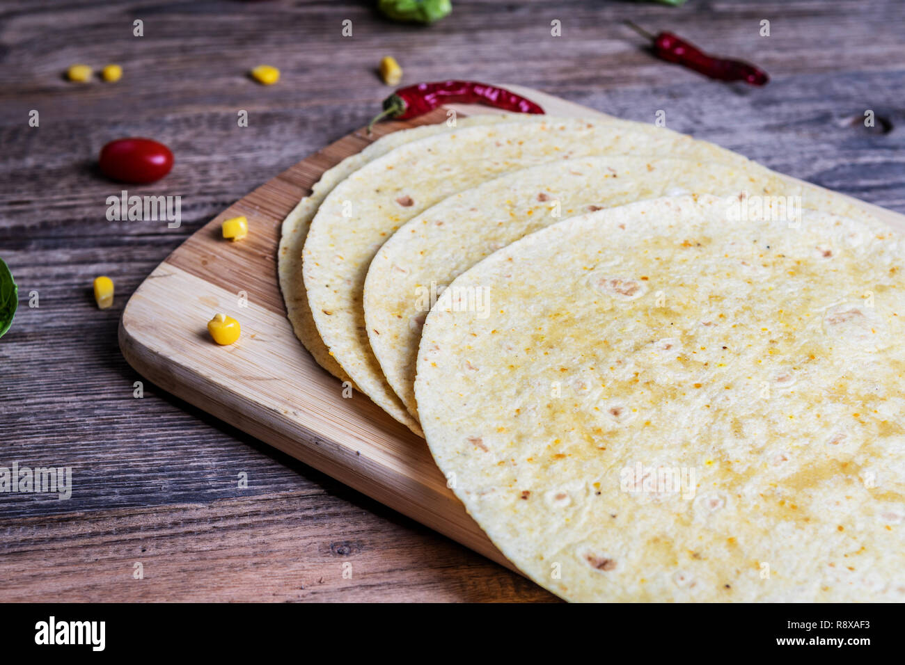 Traditional mexican tortilla wrap with vegetables and grilled chicken meat on wood table Stock Photo