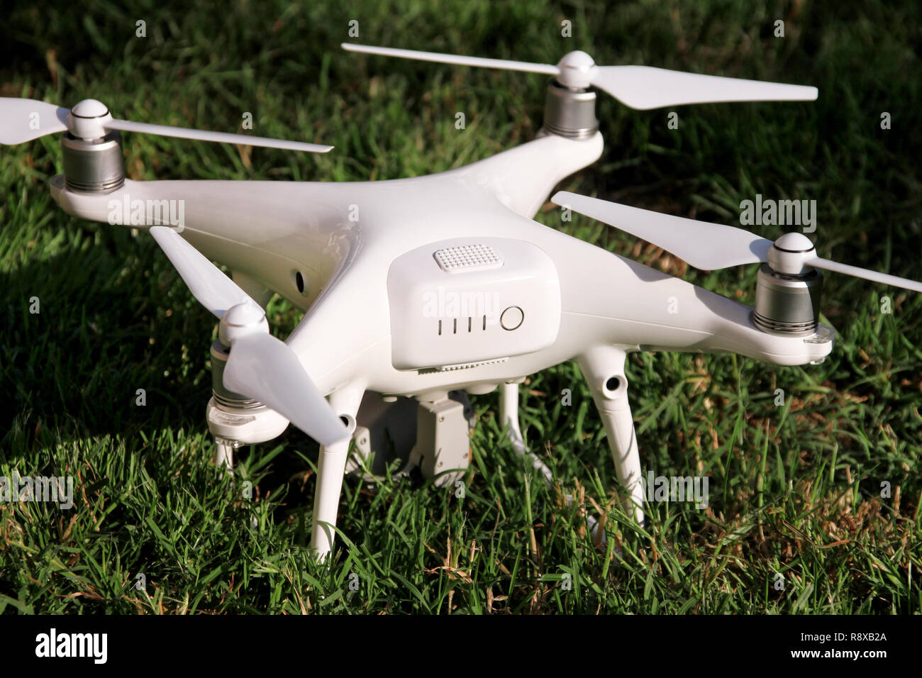 White quadcopter Drone with 4K digital camera on grass is ready for take  off to fly in air to take photos, record footage from above. Drone Stock  Photo - Alamy