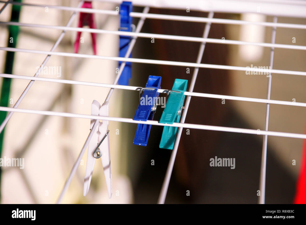 Cloth Clothespins on drying rack, selective focus. Colorful plastic clothespins on clothesline. A lot of multicolored wool cloth clamps attached. Stock Photo