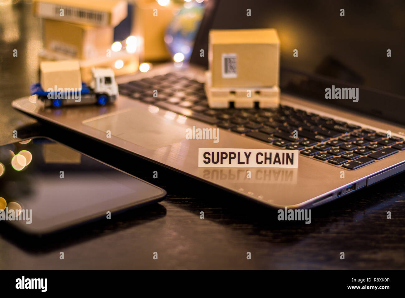 Logistics Supply Chain Challenges - still life logistics business concept with laptop, phone, mini shipping cartons Stock Photo