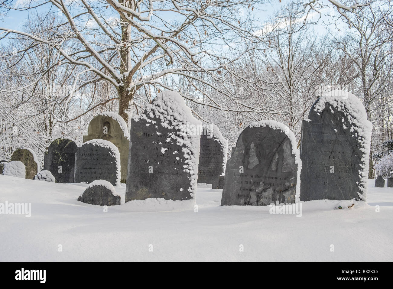 Snow covered gravestones in a cemetery in Petersham, MA in winter Stock Photo