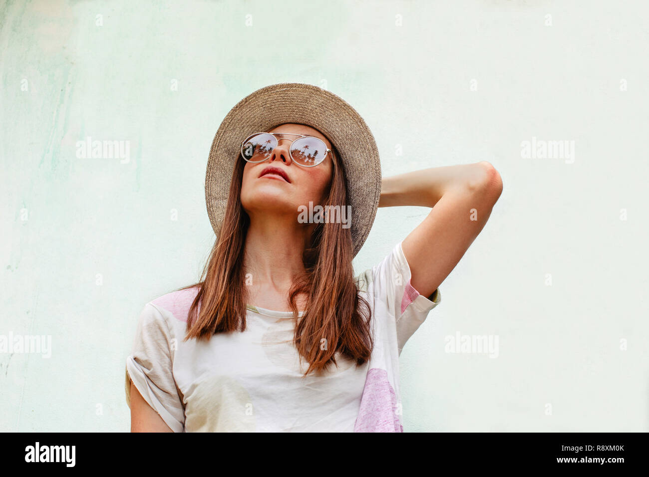 Woman in hat and sunglasses looking up Stock Photo