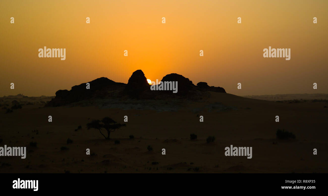 the sun rising through the sandstone formation in the Sahara desert in Ennedi, Chad Stock Photo