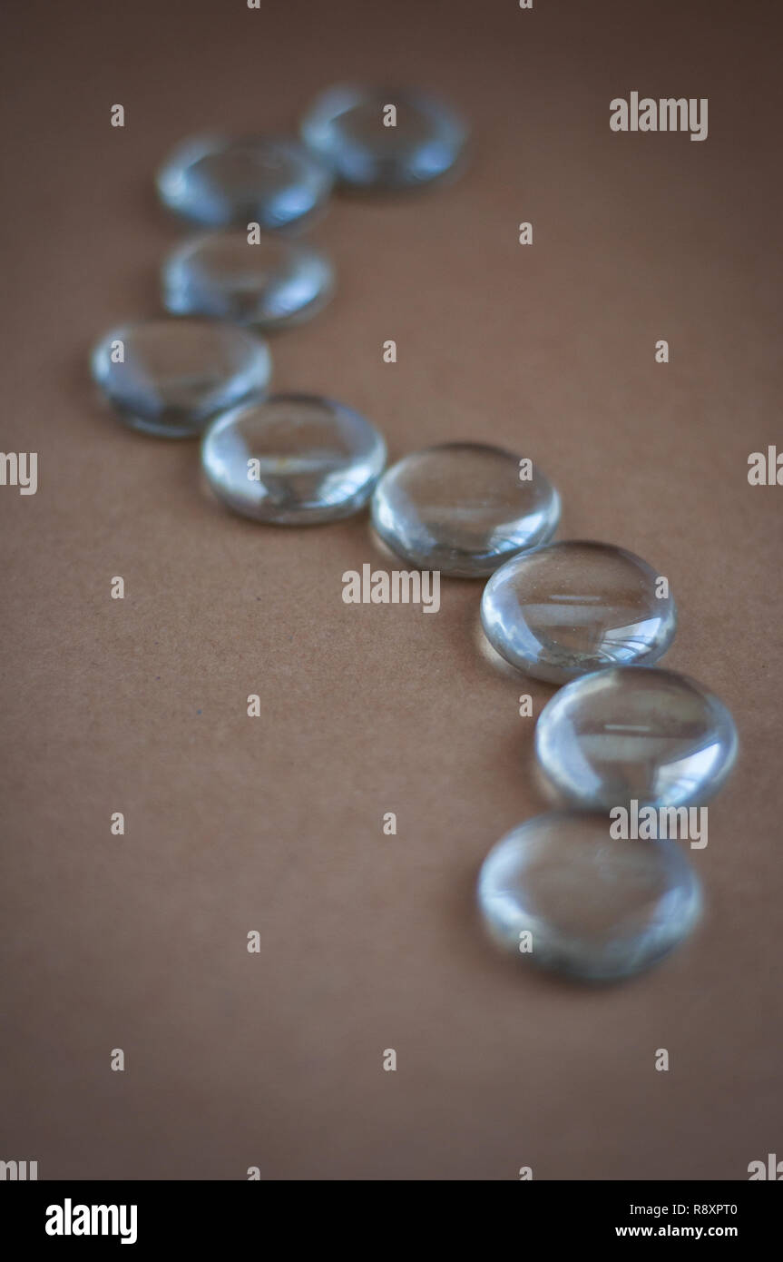 Clear marbles with light reflections on a brown background Stock Photo