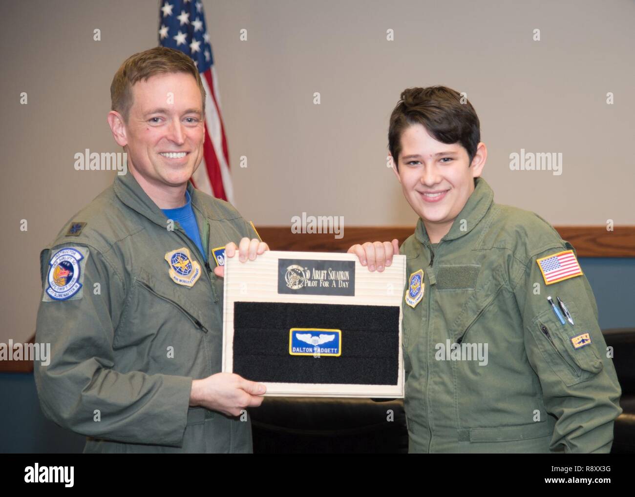 Dalton Padgett and Lt. Col. Mark Radio, 3rd Airlift Squadron commander, conclude the Pilot for a Day tour with a patching ceremony Mar. 3, 2017, at Dover Air Force Base, Del. It is an Air Force tradition for pilots to leave their name patch at the squadron when their tour of duty comes to an end. Stock Photo