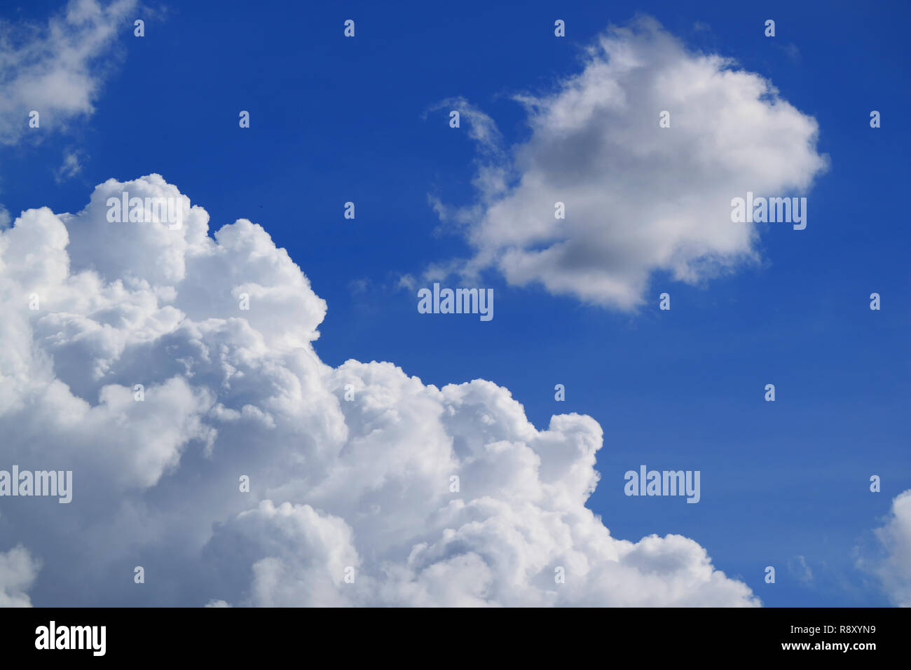White Fluffy Cumulus Clouds Floating on Vibrant Blue Sky Stock Photo