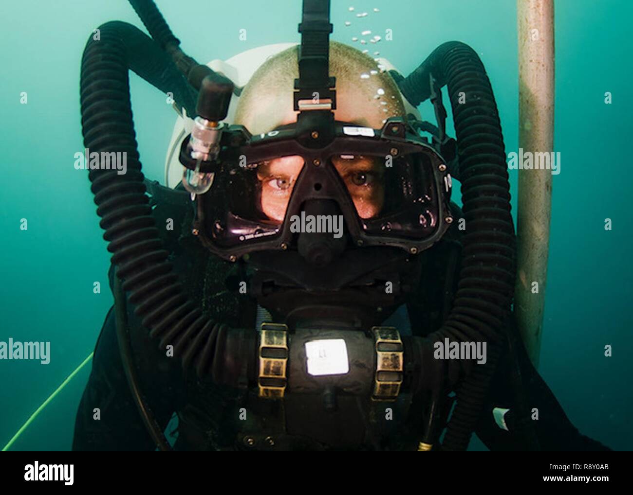 Chief Navy Diver Brian Jessup, assigned to Mobile Diving and Salvage Company ONE-SIX embarked aboard USNS Salvor (T-ARS 52), stands on a diving stage during a Defense POW/MIA Accounting Agency (DPAA) underwater recovery operation off the coast of Madang, Papua New Guinea, Dec. 7, 2018. The team was searching for personnel who went missing during WWII. DPAA conducts global search, recovery and laboratory operations to provide the fullest possible accounting of our missing personnel to their families and the nation. Stock Photo