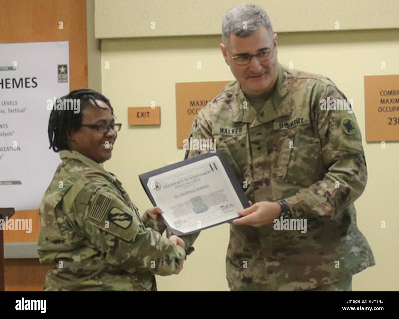 Staff Sgt. Marieka Thompson, 184th Sustainment Command receives a Hero of The Battle certificate from Brig. Gen. Clint E. Walker, 184 SC commander. Thompson was awarded for her professionalism and proficiency during the units validation for the upcoming deployment. Stock Photo