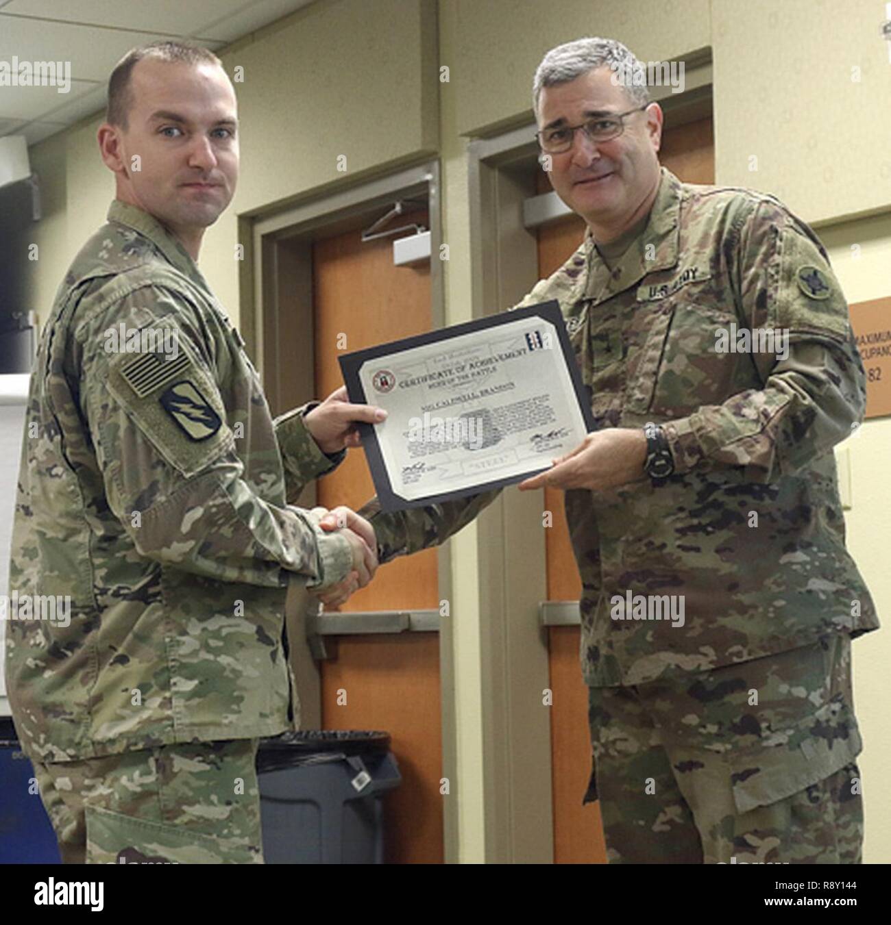 Staff Sgt. Brandon Caldwell, 184th Sustainment Command receives a Hero of The Battle certificate from Brig. Gen. Clint E. Walker, 184 SC commander. Caldwell was awarded for his professionalism and proficiency during the units validation for the upcoming deployment. Stock Photo