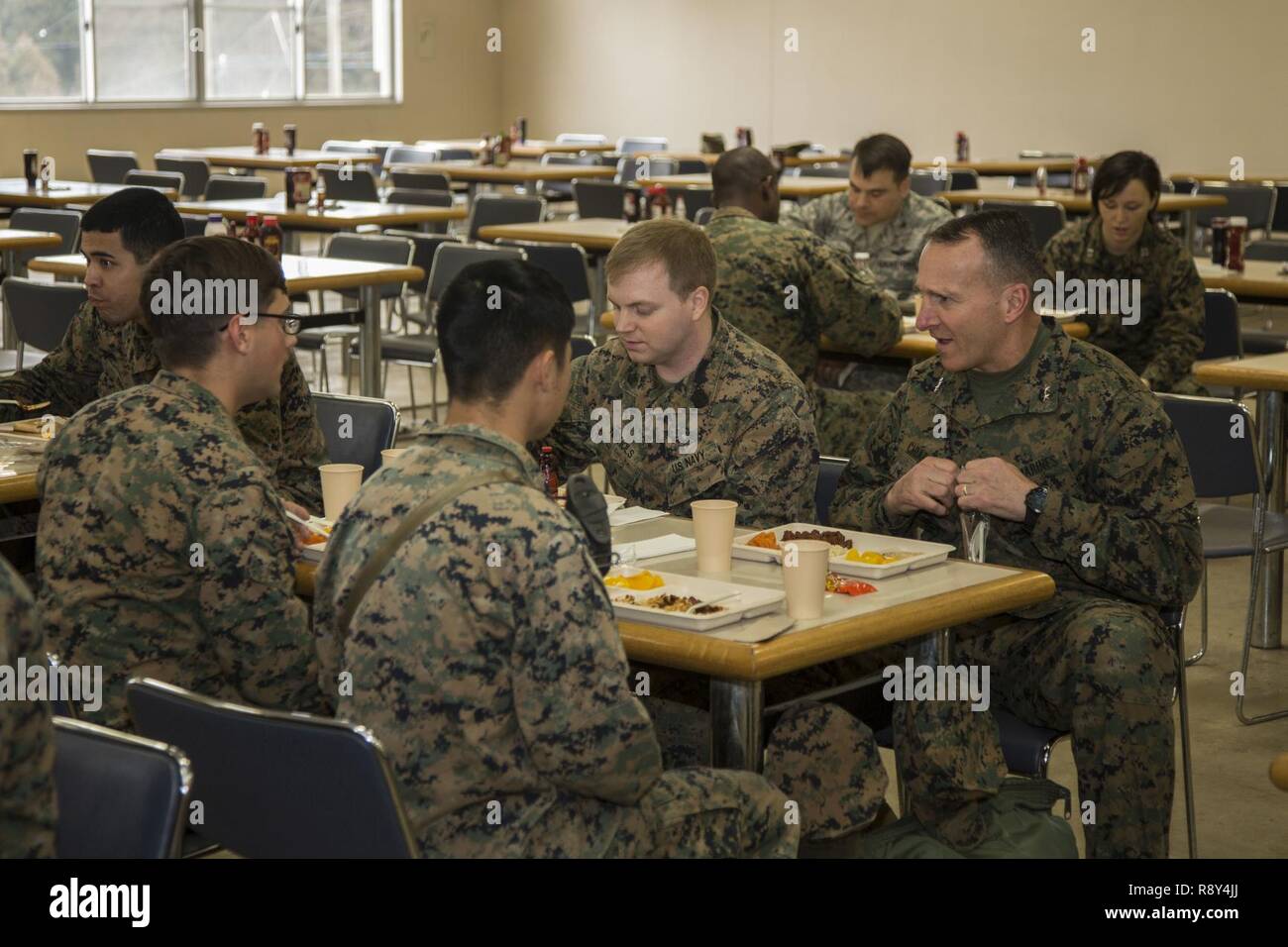 U.S. Marines with Headquarters Battery, 3rd Battalion, 12th Marines eat food at the chow hall in the Hijudai Maneuver Area, Japan, March 6, 2017. Marines and sailors participate in the artillery relocation training program to provide timely and accurate fires to sustain military occupational specialty skills, train Marines/sailors in common skills, and promote professional military education for the overall goal of enhancing combat operational readiness and international relationships. Stock Photo