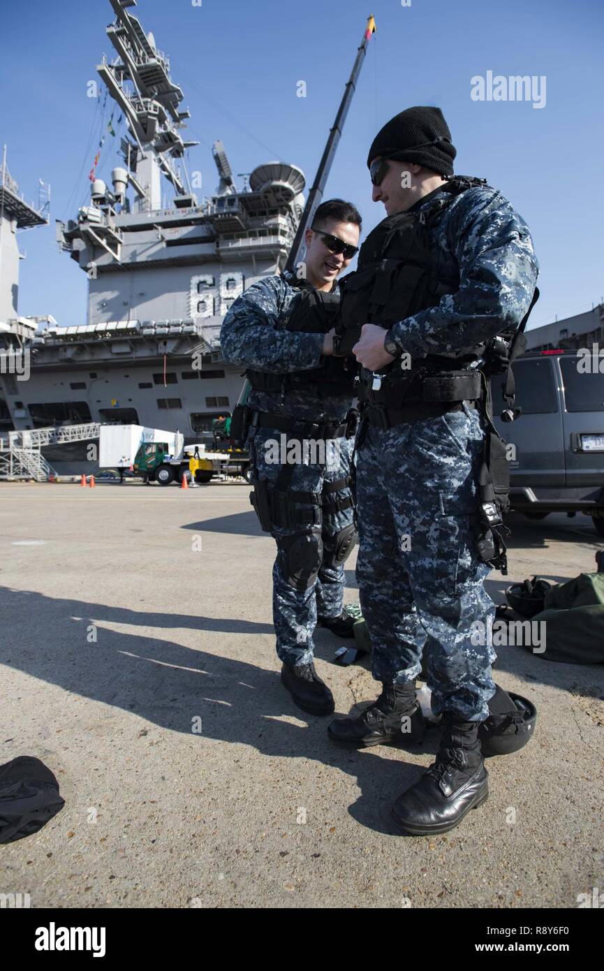 NORFOLK, Va. (March 6, 2017) Ensign Sean Jackson, left, helps Culinary Specialist 2nd Class Justin Graham, prepare for a visit, board, search, and seizure drill on a pier at Naval Base Norfolk. Both Sailors are currently assigned to the guided-missile destroyer USS Winston Churchill (DDG 81). Stock Photo