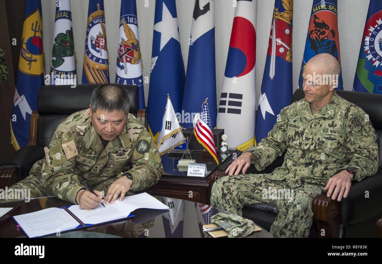 Commander, Republic of Korea (ROK) Naval Special Warfare Flotilla, Rear Adm. Jae Eun Lee, and Commander, Task Force 75, U.S. Navy Capt. Robert A. Baughman, sign an information exchange agreement in Jinhae, ROK, March 9, 2017, as part of exercise Foal Eagle 2017. The agreement addresses research and development practices between the two nations, promotes explosive ordnance disposal interoperability, and enhances future readiness. Stock Photo