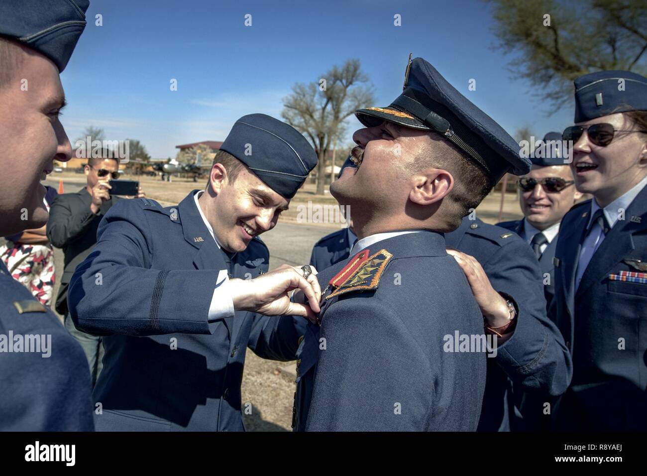 Specialized Undergraduate Pilot Training students gather to fasten pilot wings on their Iraqi Air Force classmate at Vance Air Force Base, Oklahoma, March 10. After approximately a year of training, Class 17-06 students received their wings during a morning ceremony. Stock Photo