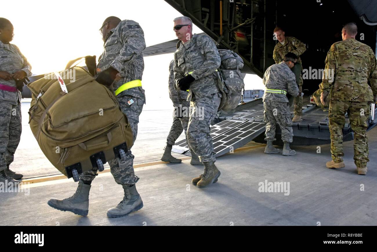 U.S. Air Force Airmen unload patients’ luggage off an aircraft at Al Udeid Air Base, Qatar, March 8, 2017. These technicians are a key component of transportation and support services between arrival and departure of patients from around the U.S. Central Command area of responsibility. Stock Photo