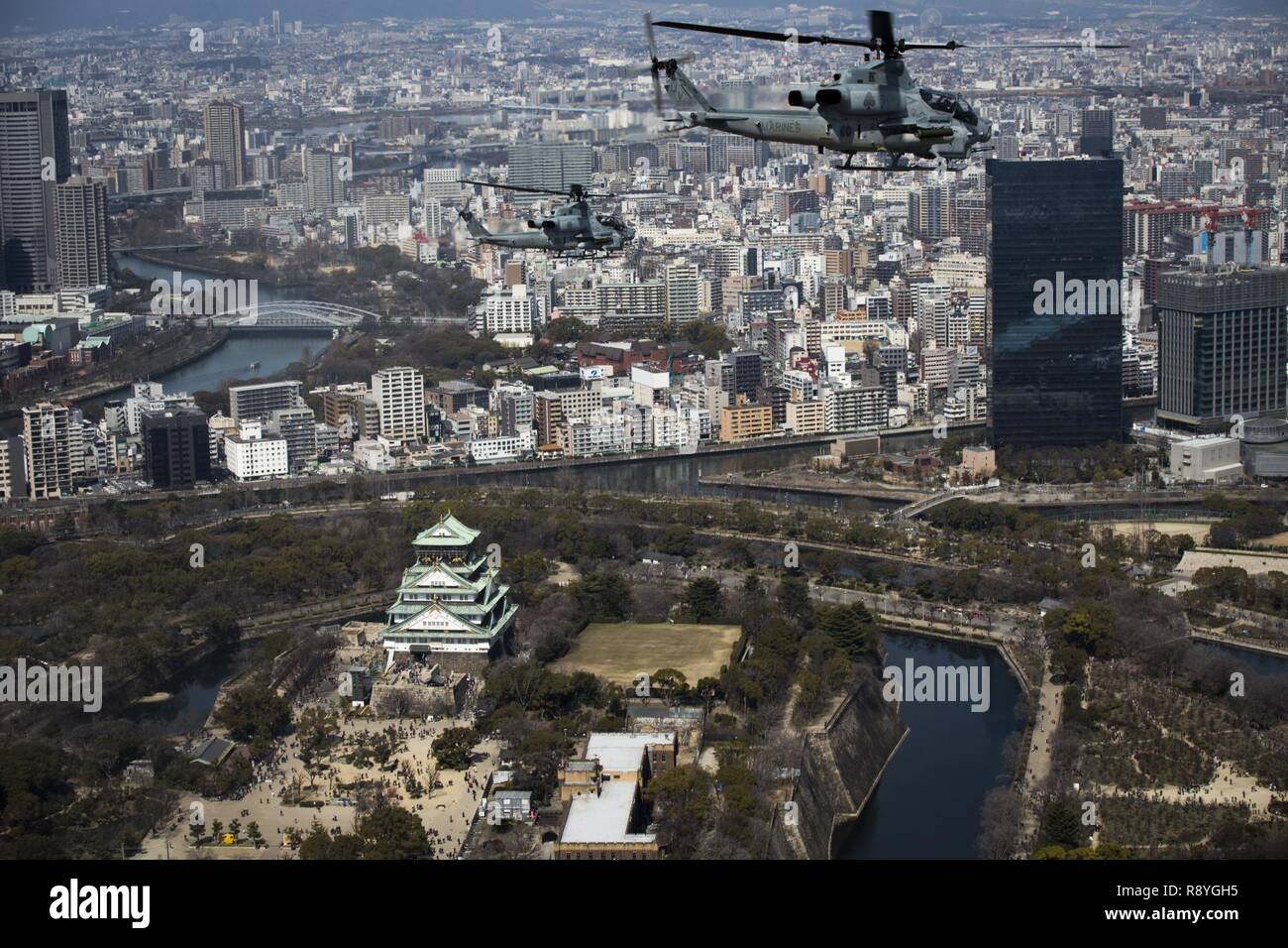 AH-1Z Vipers soar through the skies over Osaka Castle, Osaka, Japan, March 12, 2017. Marine Light Attack Helicopter Squadron 267 validated the long-range capability of the auxiliary fuel tanks on their H-1 platform helicopters by flying 314 nautical miles during one leg of the journey, March 10. These aircrafts’ extended range is crucial to maintaining a stronger, more capable forward-deployed force in the Asia-Indo-Pacific region. The Marines in the aircraft are with HMLA-267, currently assigned to Marine Aircraft Group 36, 1st Marine Aircraft Wing, III Marine Expeditionary Force through the  Stock Photo