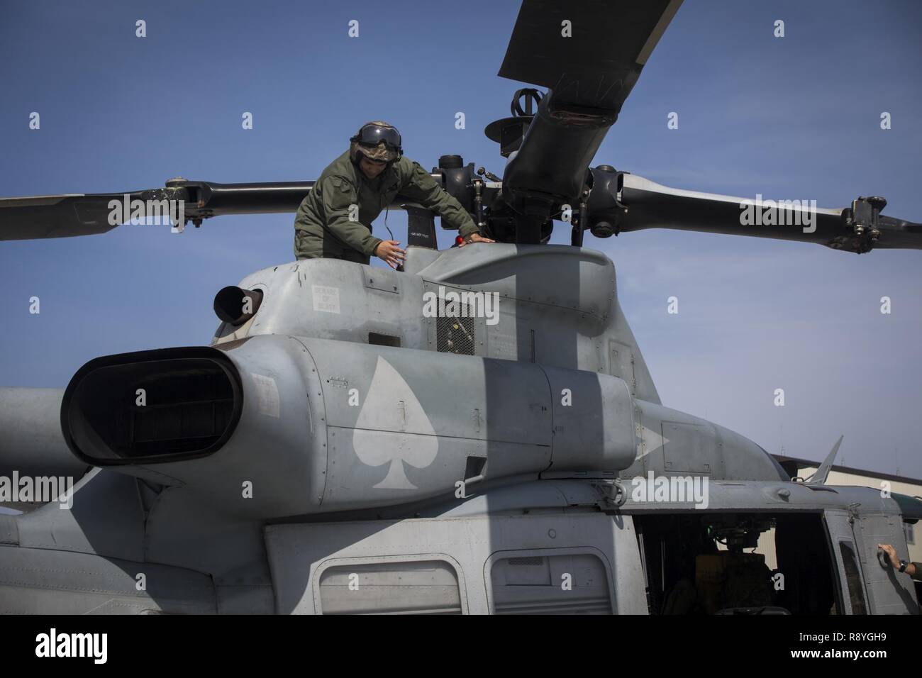 Sgt. Kevin Carpio, a UH-1Y Venom crew chief with Marine Light Attack Helicopter Squadron 267, currently assigned to Marine Aircraft Group 36, 1st Marine Aircraft Wing, III Marine Expeditionary Force through the unit deployment program, inspects helicopter propellers at Marine Corps Air Station Iwakuni, Japan, March 12, 2017. The squadron, based out of Camp Pendleton, California, validated the long-range capability of the auxiliary fuel tanks on their H-1 platform helicopters by flying 314 nautical miles during one leg of the journey, March 10. These aircrafts’ extended range is crucial to main Stock Photo