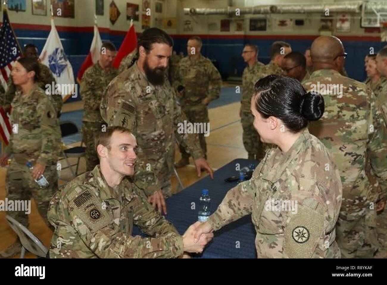 Retired Army Sgt. Willard Hoyum, wheeled vehicle mechanic, formerly with A company, 307th Brigade Support Battalion, 82nd Airborne Division, shakes the hand of a deployed Soldier, March 14, 2017, Camp Arifjan, Kuwait. The meet and greet concluded the first town hall meeting Soldiers of Operation Proper Exit will give prior to returning to the location where they received their combat injuries. Stock Photo