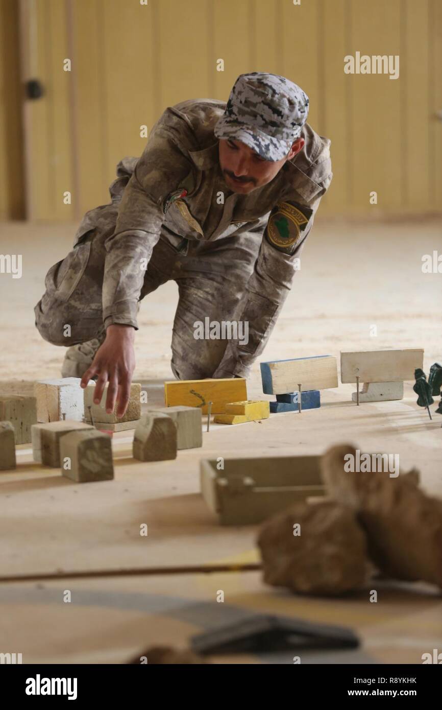 An Iraqi security forces soldier uses a rock drill to explain safety protocols to defeat an improvised explosive device during counter - IED training at Al Asad Air Base, Iraq, March 18, 2016. This training is part of the overall Combined Joint Task Force – Operation Inherent Resolve building partner capacity mission by training and improving the capability of partnered forces fighting ISIS. CJTF-OIR is the global Coalition to defeat ISIS in Iraq and Syria. Stock Photo