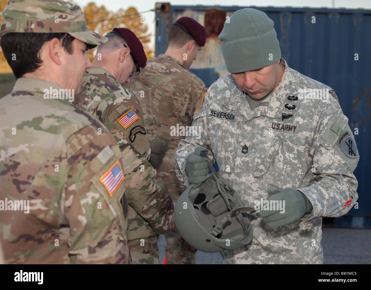 U.S. Army Sgt. 1st Class Andrew Severson of the 15th Psychological Operations Battalion inspects an Advanced Combat Helmet during sustained airborne training to prepare for a static line jump on Fort Gillem, Ga., March 3, 2017. The paratroopers jump to fulfill Airborne obligations while also building confidence and experience, ensuring they remain mission capable. Stock Photo