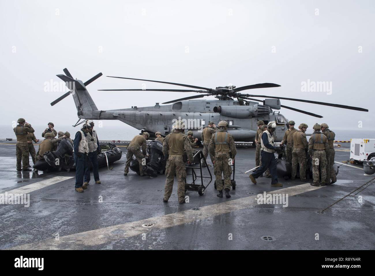 PHILIPPINE SEA (March 19, 2017) Reconnaissance Marines, assigned to the Maritime Raid Force (MRF) of the 31st Marine Expeditionary Unit (MEU), place rotors on three combat rubber raiding crafts (CRRC) on the flight deck of amphibious assault ship USS Bonhomme Richard (LHD 6) in preparation for a helo cast exercise. A helo cast is a method used to insert reconnaissance and surveillance teams for amphibious reconnaissance missions requiring small boat operations. Bonhomme Richard, flagship of the Bonhomme Richard Expeditionary Strike Group, with embarked 31st MEU is on a routine patrol, operatin Stock Photo