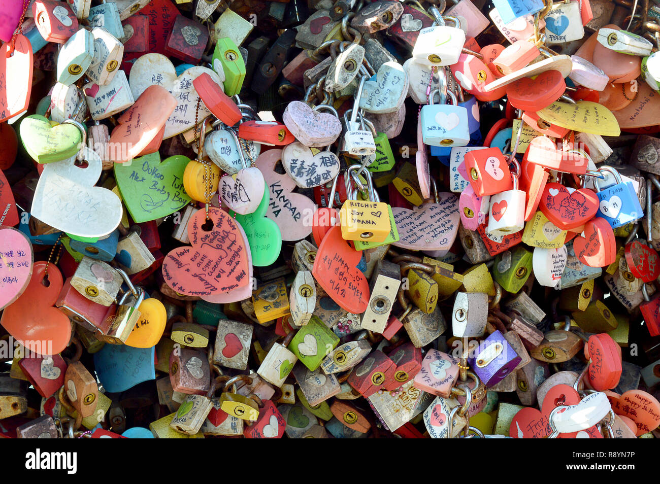 Wall with collection of of padlocks that have been hung and locked into place on Seoull Tower, Korea, to symbolise endless love between couples Stock Photo